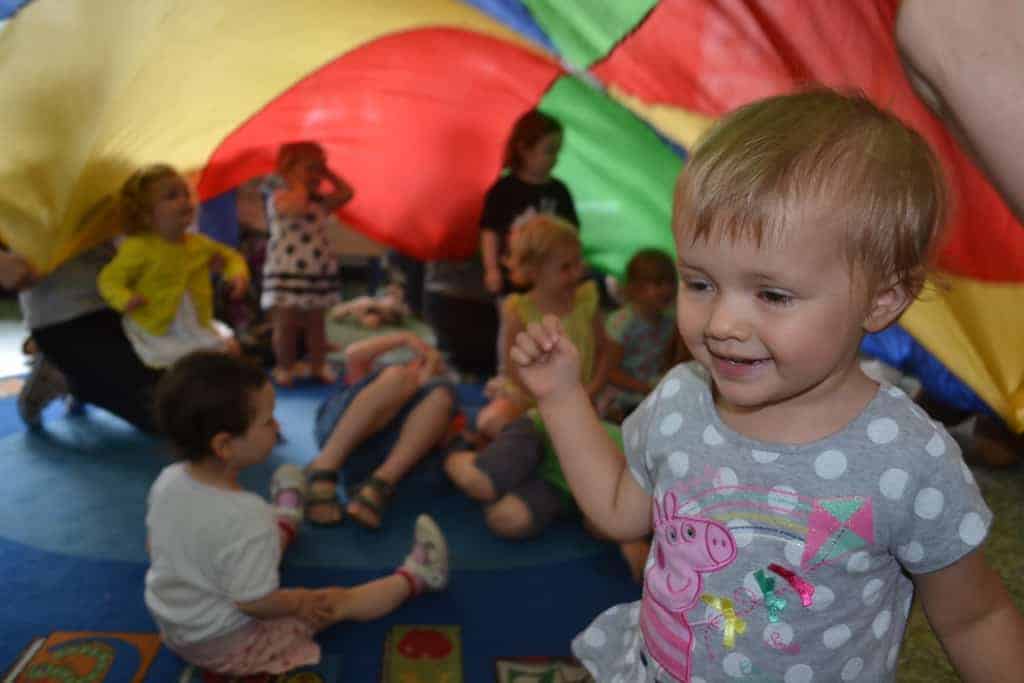 Toddler playing party parachute game