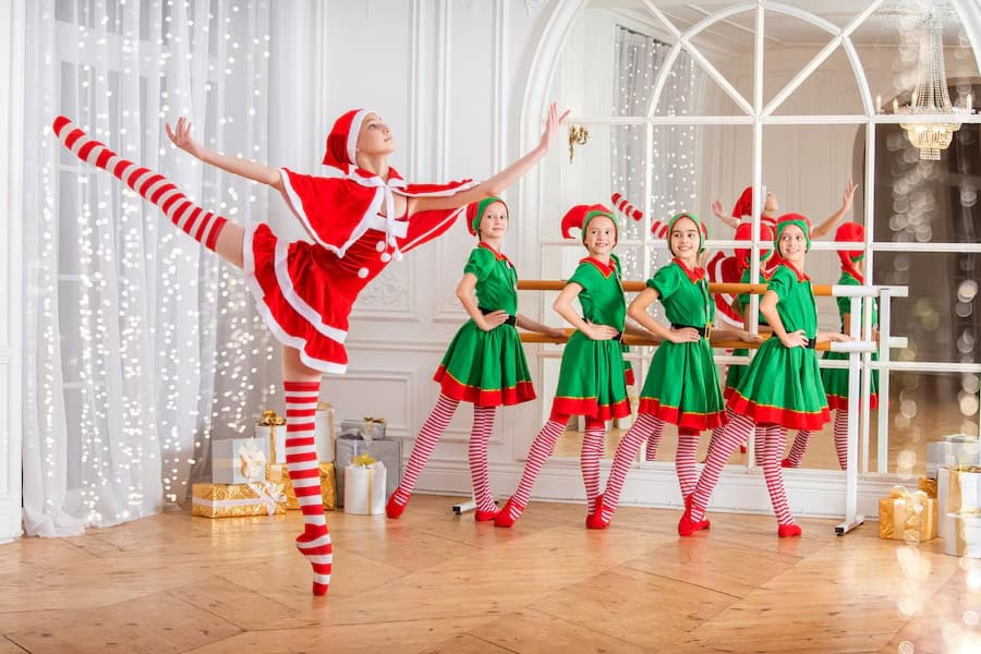 A group of women dressed in festive Christmas costumes poses joyfully for a photo at the Captain Christmas Magical Elf Show.