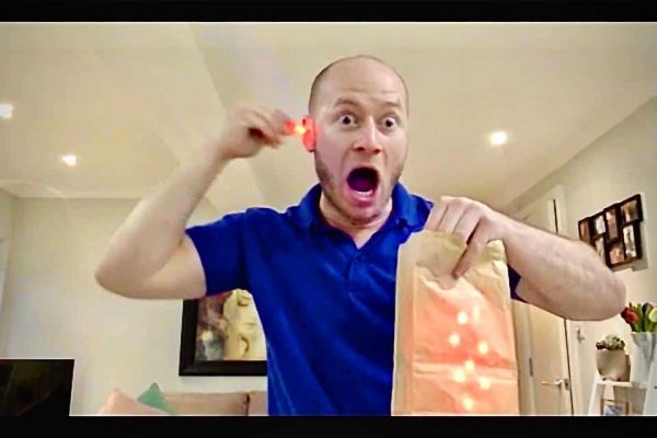 A man holds a food bag illuminated by a light, symbolizing the joy of online interactive parties.